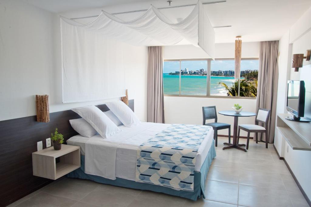 a bedroom with a bed and a view of the ocean at Ritz Suites Lifestyle in Maceió