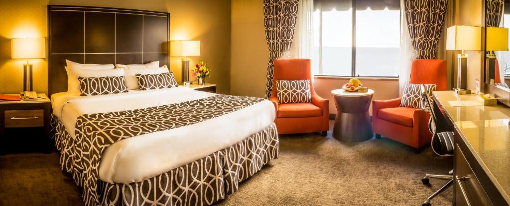 ロサンゼルスにあるNew Seoul Hotelの大きなベッドと椅子のあるホテルの部屋