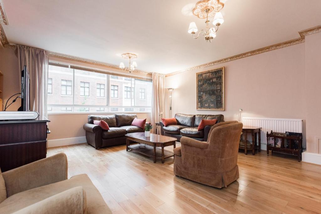 a living room with two couches and a table at Prime London Apartment, Oxford Circus in London