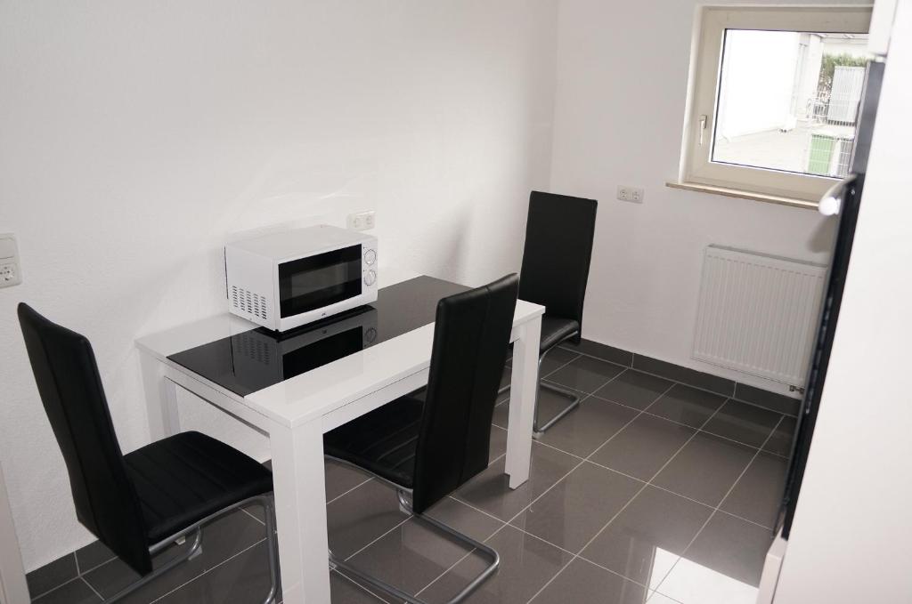 a room with a desk with a computer and chairs at SoNi Apartment in Dieburg