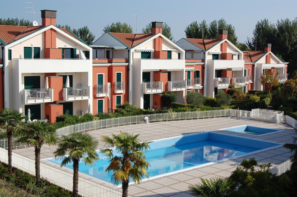 um complexo de apartamentos com piscina e palmeiras em Residence Ca' D'Oro em Cavallino-Treporti