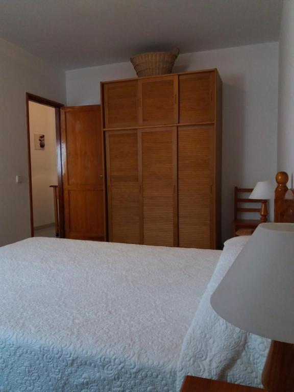 1 dormitorio con 1 cama grande y armario de madera en Terrazas de Lanzarote, en Arrecife