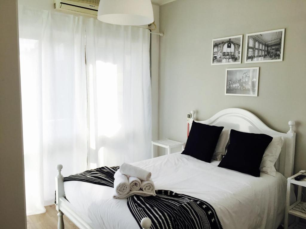 a bedroom with a white bed and a window at Mirandesa Guesthouse in Porto