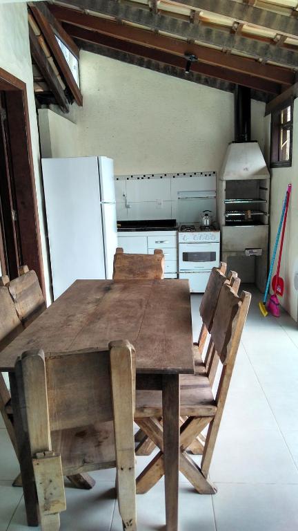 a wooden table and chairs in a kitchen at Condominio Sargento Laranja in Garopaba
