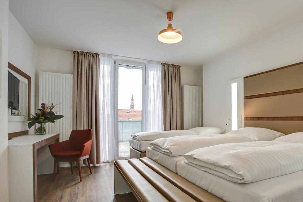 pokój hotelowy z 3 łóżkami i oknem w obiekcie INA Boutique 030 Hannover-City w Hanowerze