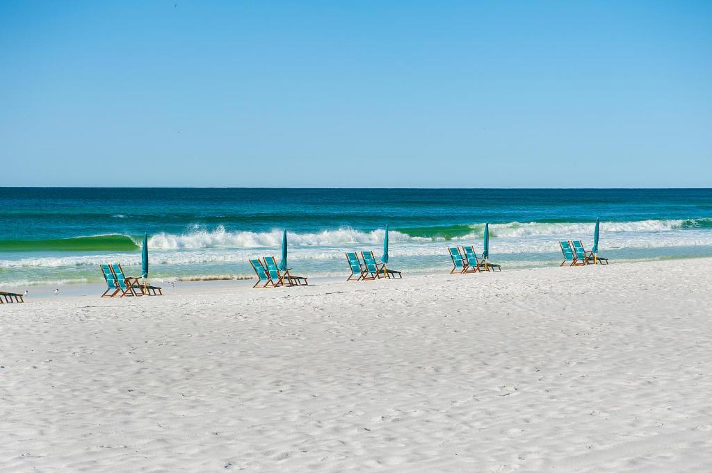 a group of chairs sitting on the beach at Getaways at Destin Holiday Beach Resort in Destin