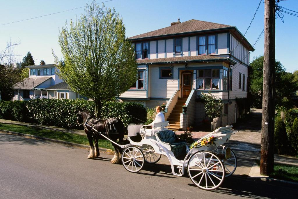 un carruaje tirado por caballos frente a una casa en Marketa's Bed and Breakfast, en Victoria