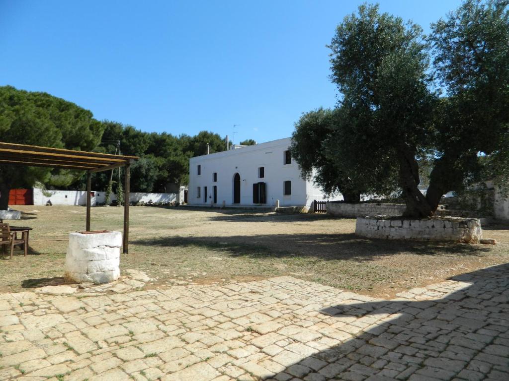 un edificio blanco con un árbol delante en Masseria Purgatorio, en Fasano
