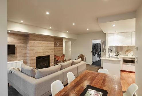 a living room with a couch and a table and a kitchen at Alto Villa 304 in Mount Buller