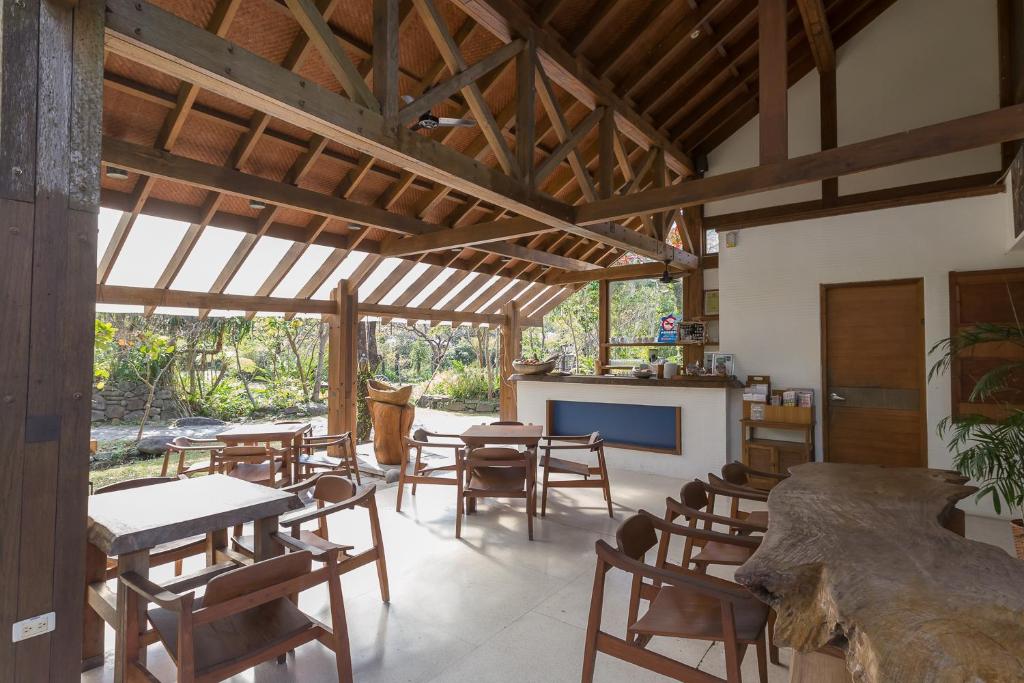 a dining room with tables and chairs and a tv at Mudanwan Villa in Mudan