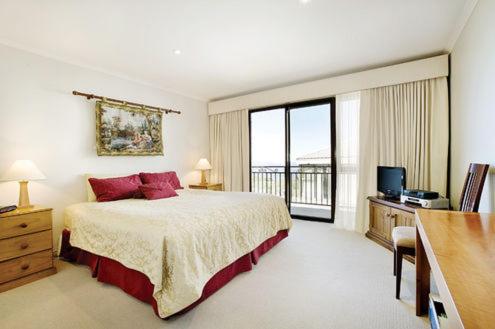 a bedroom with a large bed and a balcony at Pension Grimus Zurs Suite in Mount Buller