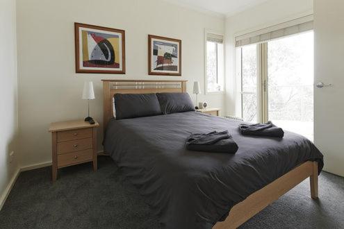 a bedroom with a large bed and a window at Reindeer 9 in Mount Buller