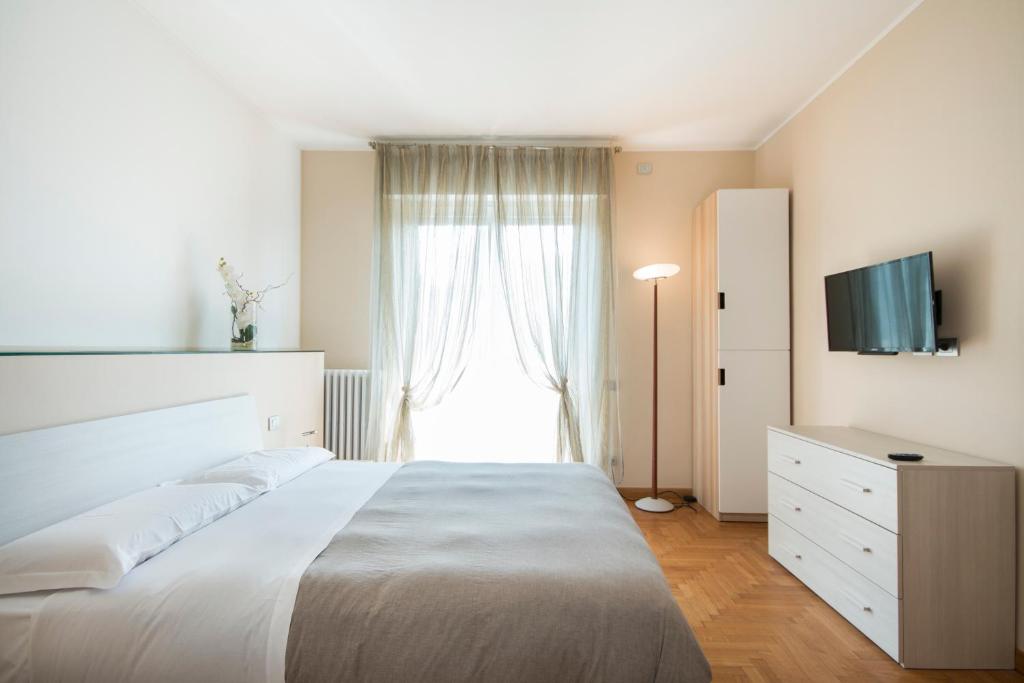 una camera da letto con un grande letto bianco e una finestra di Casa Foscolo a Villa Guardia