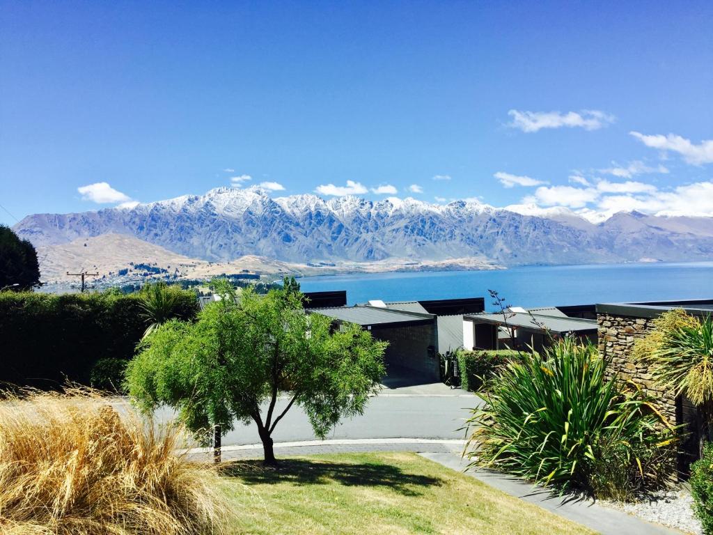 ein Haus mit Blick auf das Wasser und die Berge in der Unterkunft Distinctive Alpine Meadows in Queenstown