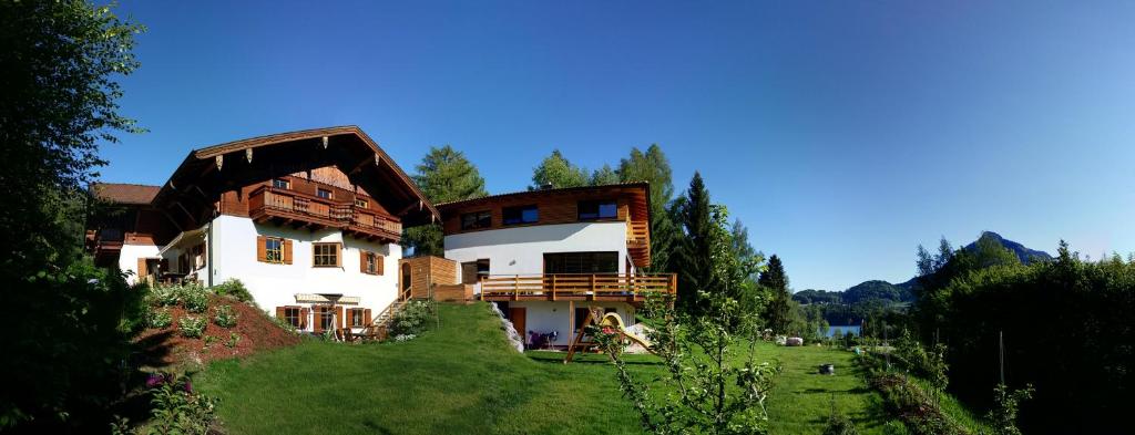 una casa grande en la cima de un campo verde en Apartments Seegartl en Fuschl am See