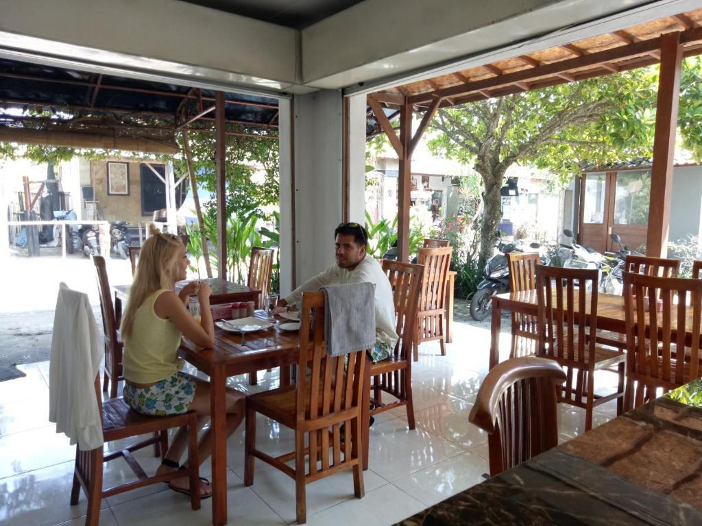 a man and woman sitting at a table in a restaurant at Radya Homestay in Nusa Lembongan