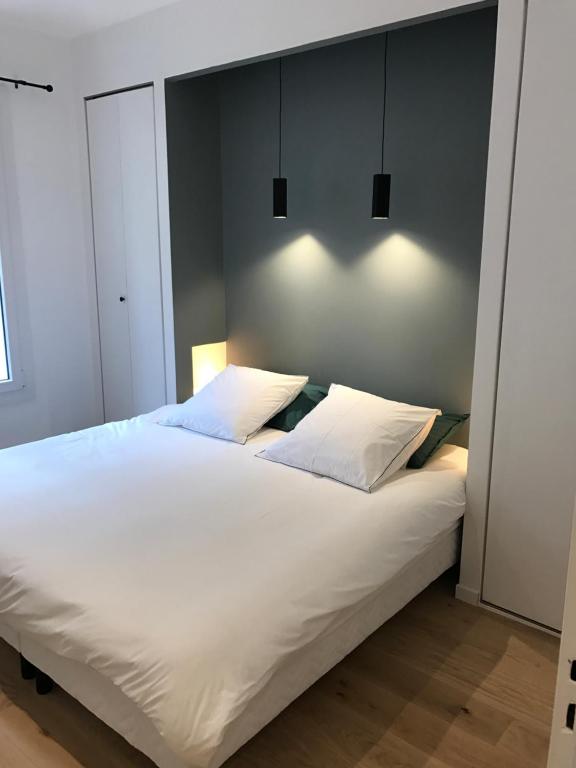 ein Schlafzimmer mit einem großen weißen Bett mit zwei Kissen in der Unterkunft Le Luciole in Marseille