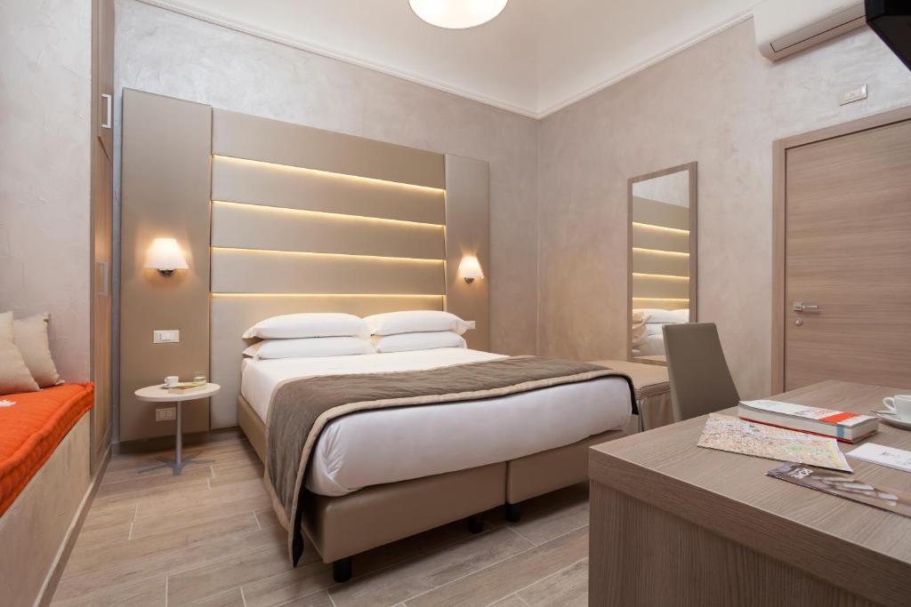 een hotelkamer met een bed en een bureau met een bureau bij Jackie's Apartments in Rome