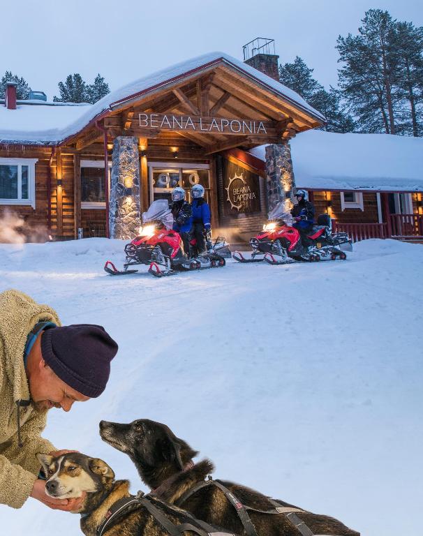 MeltausにあるBeana Laponia - Wilderness boutique hotel with safarisのスキー場前の犬二匹の男