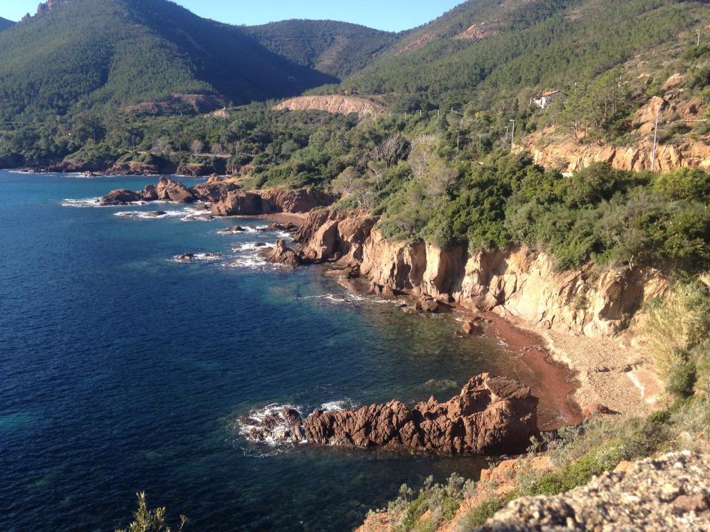 an aerial view of the ocean and a rocky coast at Plage de Miramar in Théoule-sur-Mer