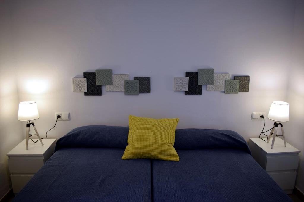 a bedroom with a bed with a yellow pillow on it at El Jardin BeNerja in Nerja