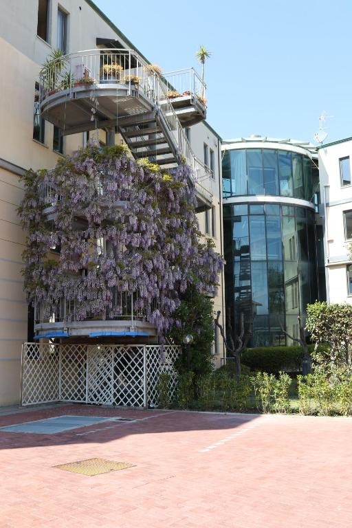 a tree with purple flowers on the side of a building at L'incanto Di Boccadarno in Marina di Pisa