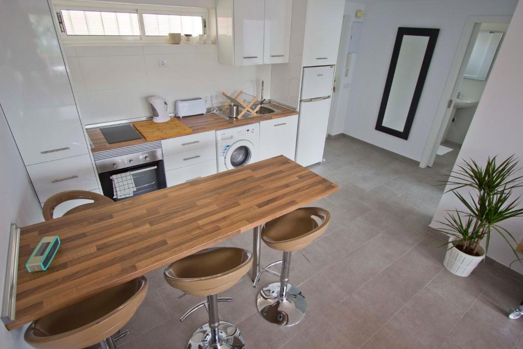 a kitchen with a wooden table and stools at Apartment Terrace Benalmádena in San Francisco