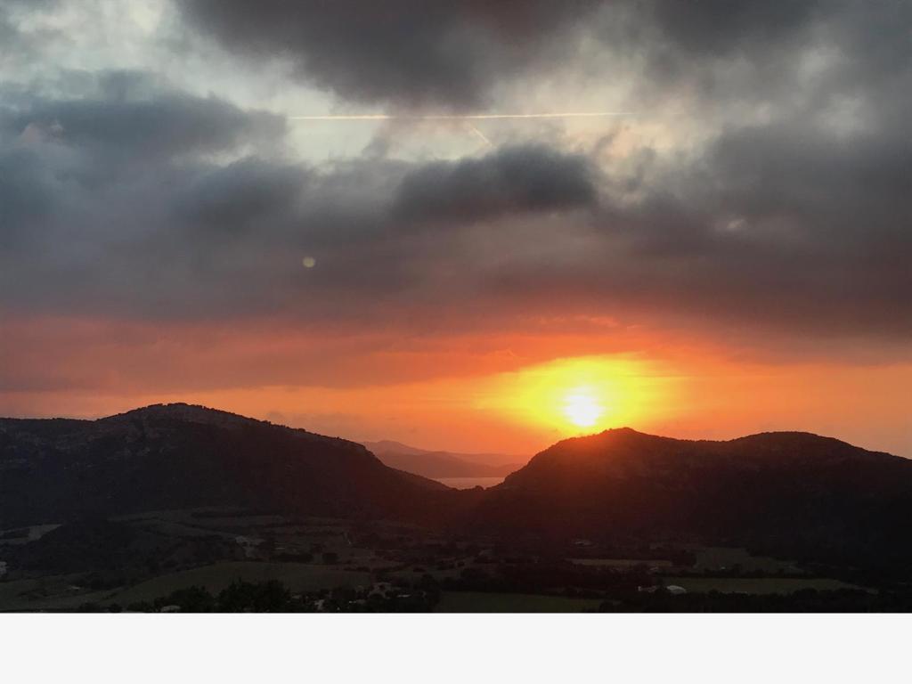 un tramonto con il sole che tramonta sulle montagne di Casale a Figa Bianca a Patrimonio