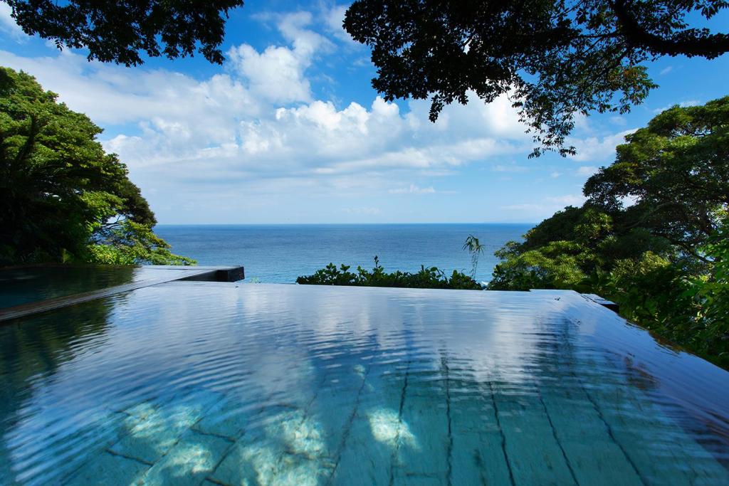 a swimming pool with a view of the ocean at Kissho Caren in Higashiizu