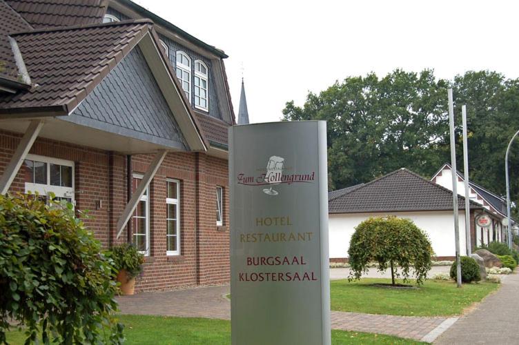 un cartel frente a una casa de ladrillo en Hotel Restaurant Zum Hollengrund en Heeslingen
