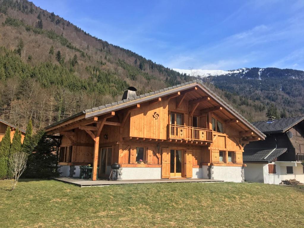 um homem parado no telhado de uma casa de madeira em Chalet Pétérets em Samoëns