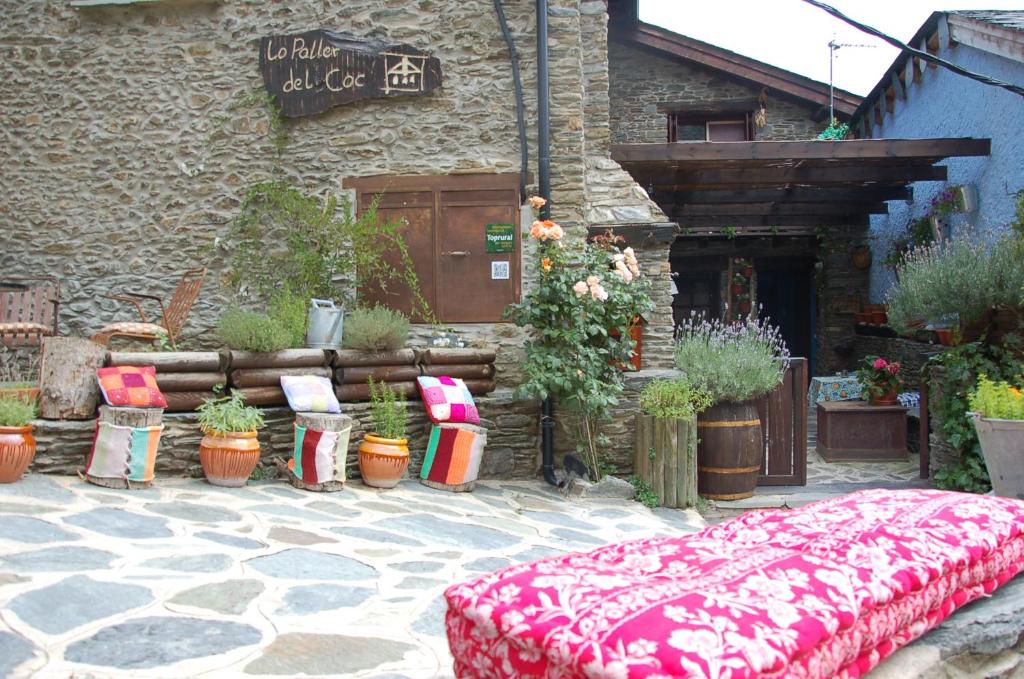 a bed in front of a building with potted plants at La Llar-Lo Paller del Coc in Surp