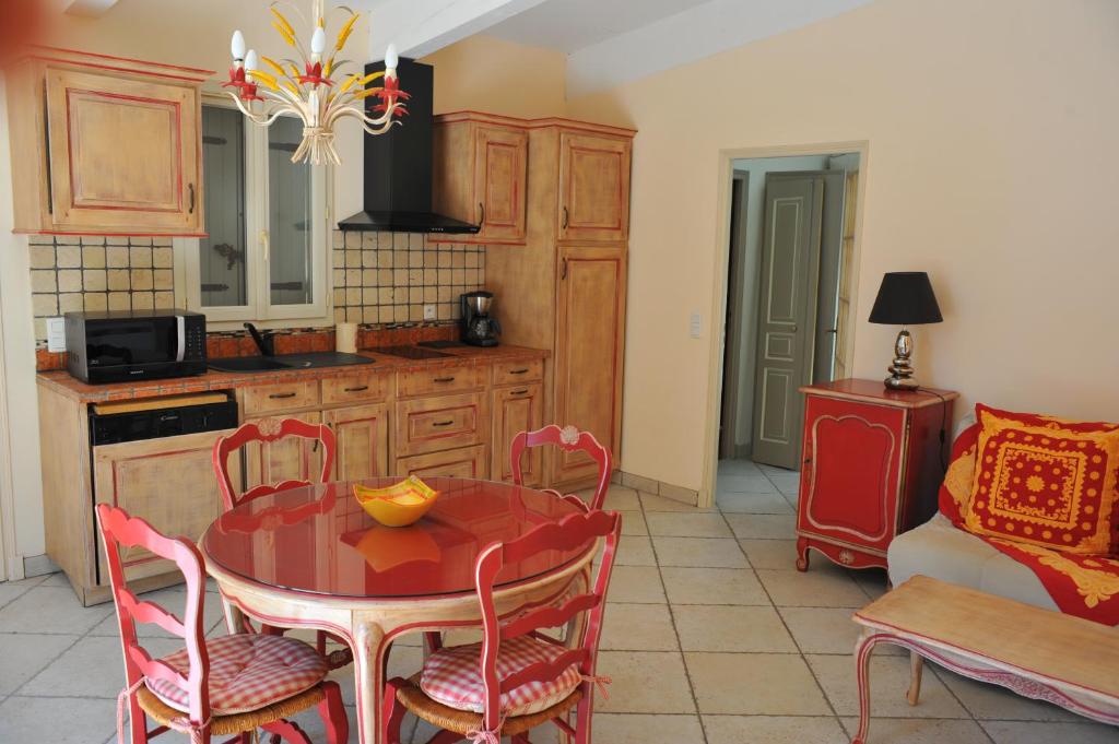 a kitchen with a red table and chairs in a room at Villa Valflor chambres d'hôtes et appartements in Marseille