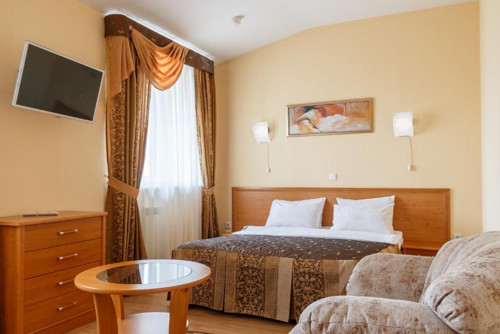 a hotel room with a bed and a couch at Hotel Ingriya in Kolpino