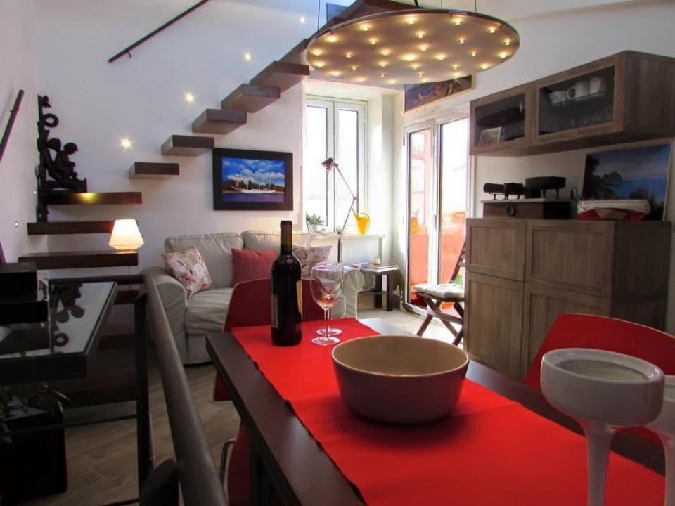 ein Wohnzimmer mit einem roten Tisch und einer Flasche Wein in der Unterkunft Arias - la suite del Duomo in Cefalú