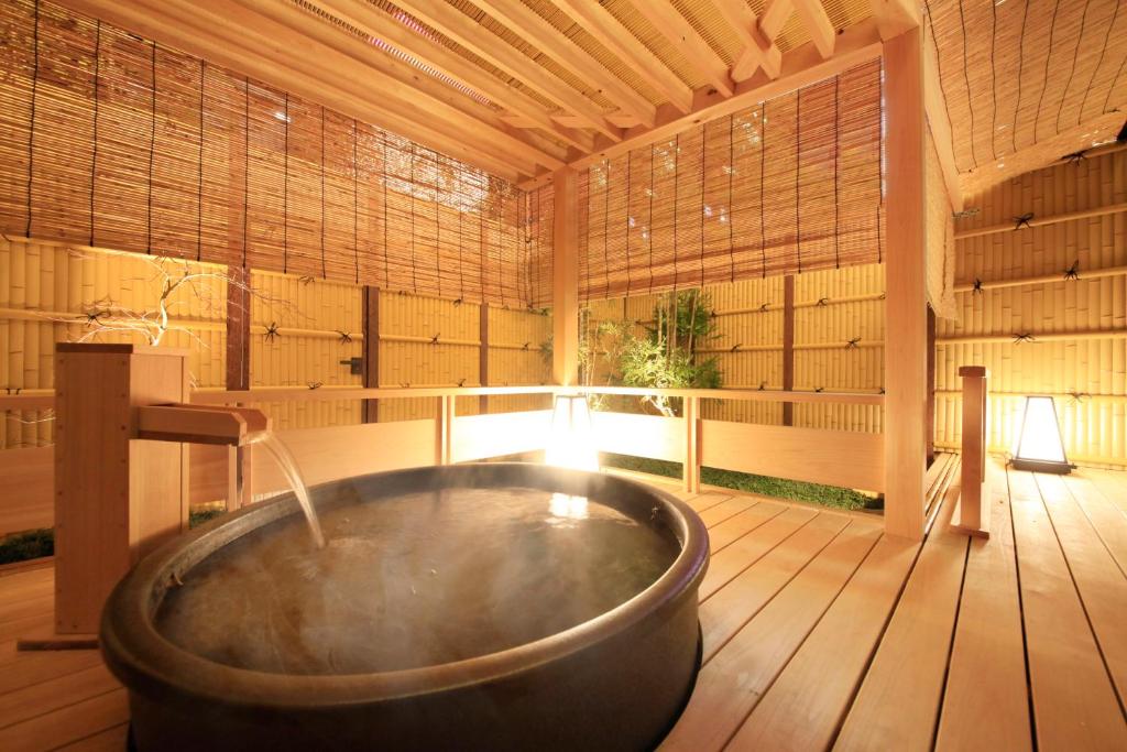 uma grande banheira num quarto com uma janela em Centurion Hotel Ueno em Tóquio