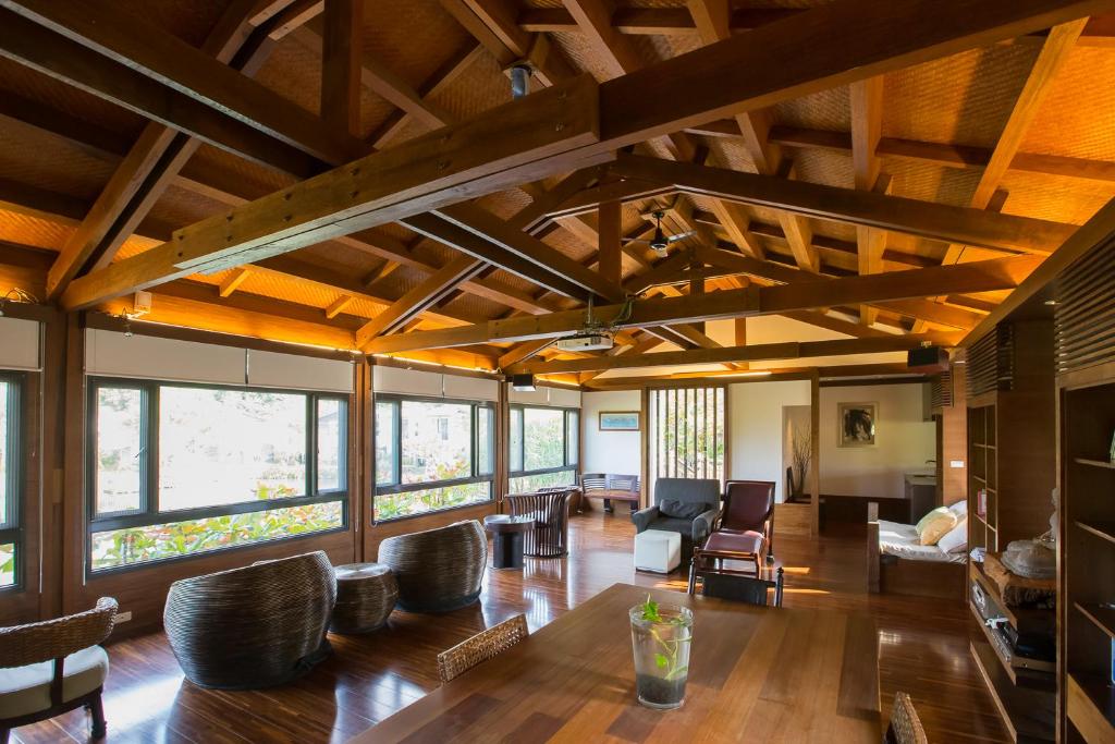 a large living room with wooden ceilings and chairs at Mudanwan Villa in Mudan