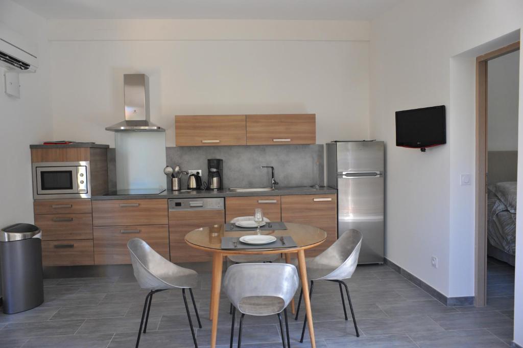 a kitchen with a table and chairs in a kitchen at Villa Valflor chambres d'hôtes et appartements in Marseille