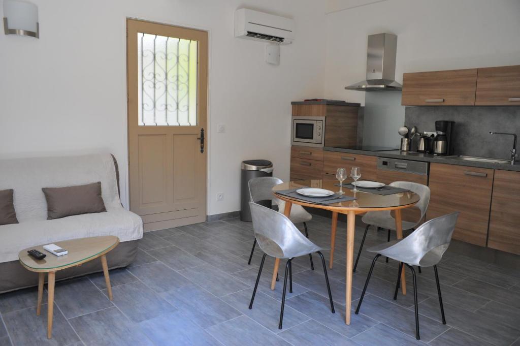 a kitchen and a living room with a table and chairs at Villa Valflor chambres d'hôtes et appartements in Marseille