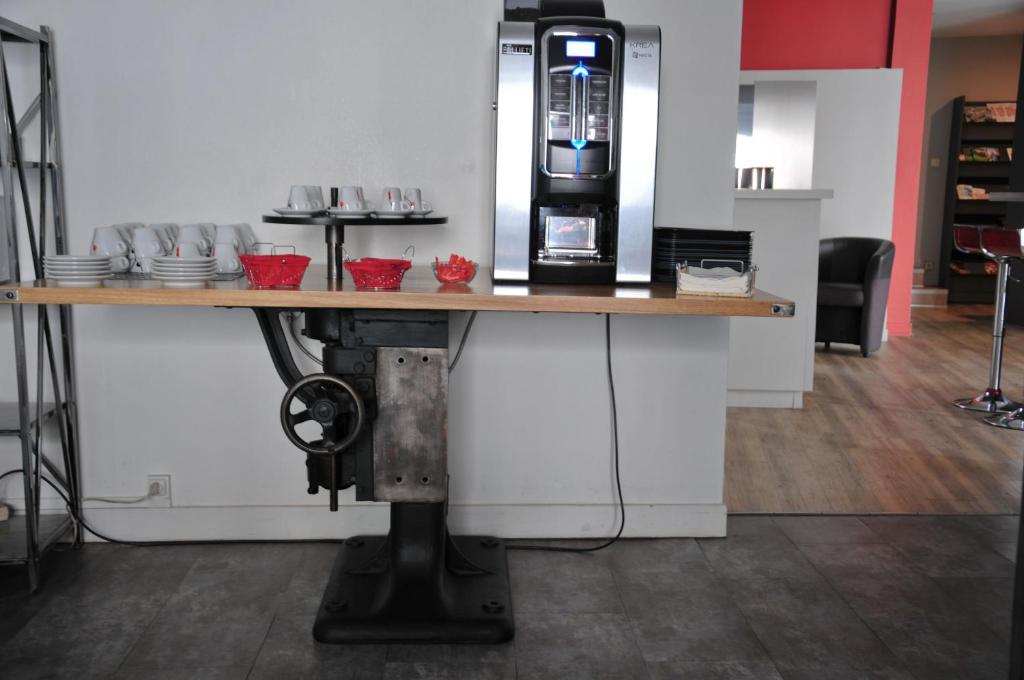 a table with a coffee machine on top of it at Cit&#39;Hotel Europeen in Angoulême