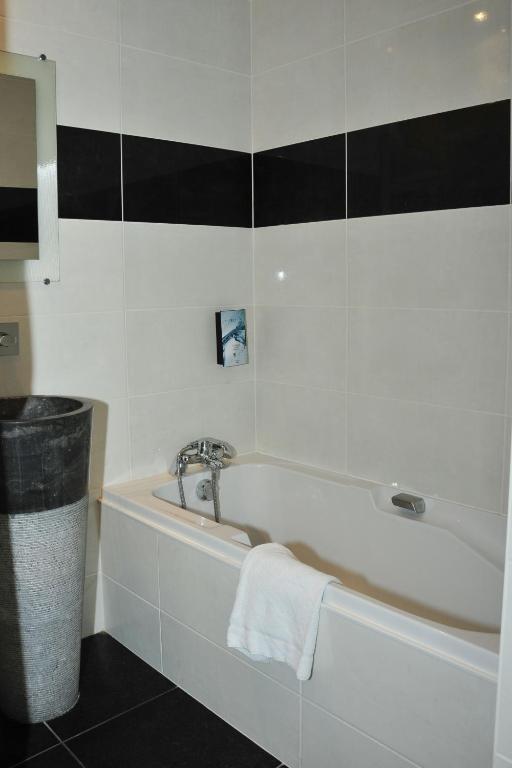 a bathroom with a bath tub and a sink at Cit&#39;Hotel Europeen in Angoulême