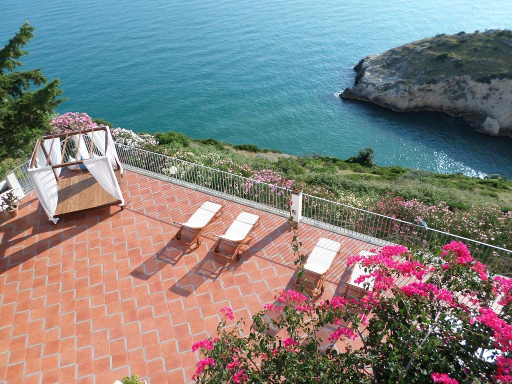 um pátio com cadeiras e vista para o oceano em Baia Scirocco Bed and Breakfast em Peschici