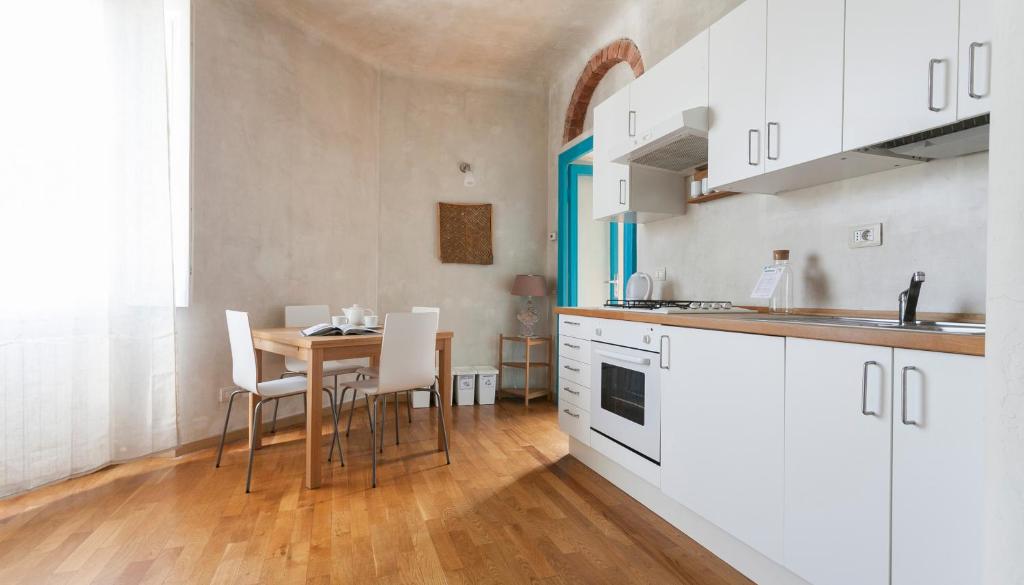 ミラノにあるItalianway-Pastrengo 11のキッチン(白いキャビネット、テーブル、椅子付)