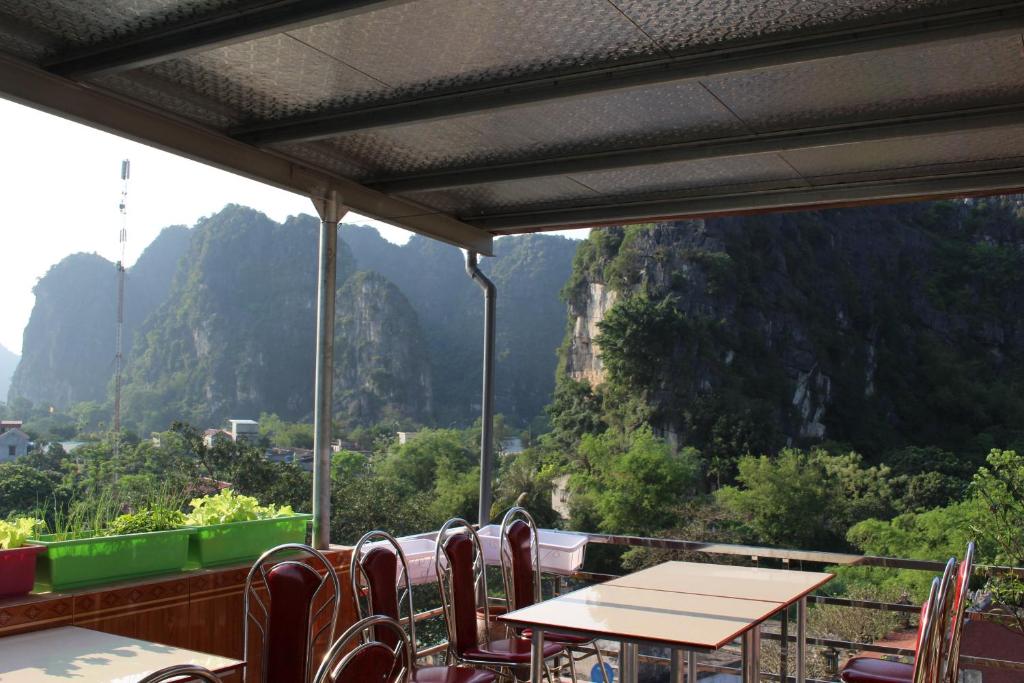 a table and chairs on a balcony with a view of mountains at Sierra Homestay in Ninh Binh
