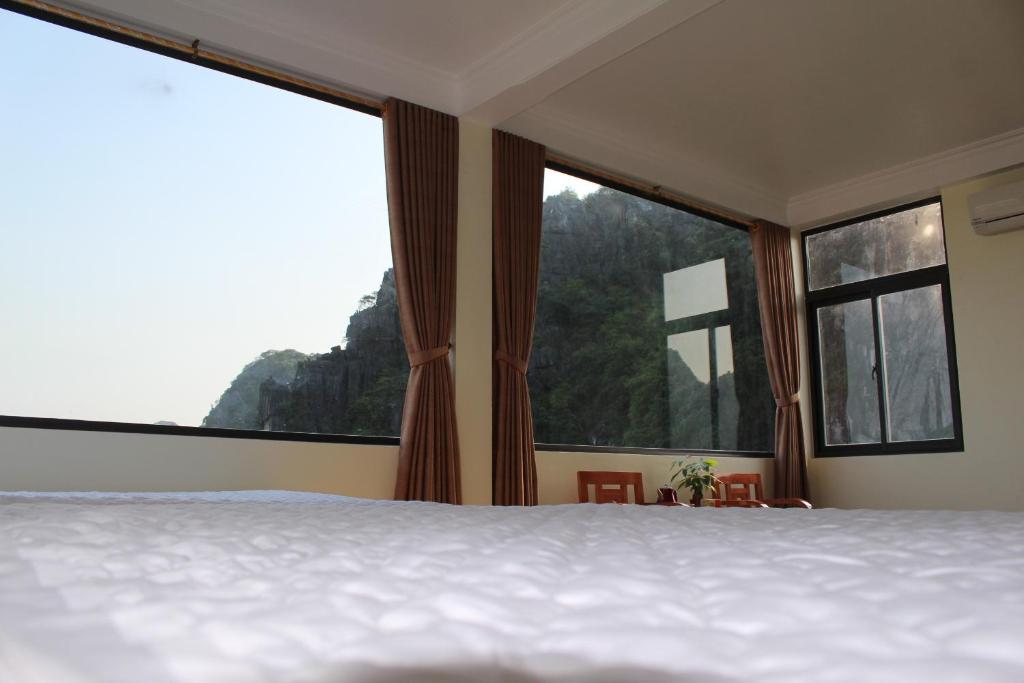 a bedroom with a bed and large windows at Sierra Homestay in Ninh Binh