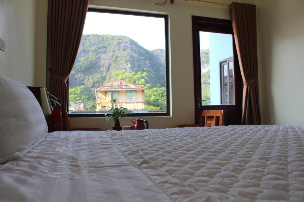 a bedroom with a bed and a large window at Sierra Homestay in Ninh Binh
