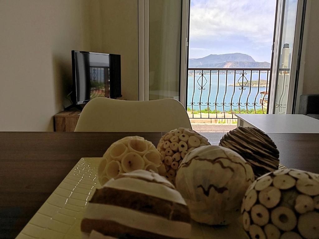 a table with cookies on it with a view of the ocean at Demeliza Apartments in Plaka