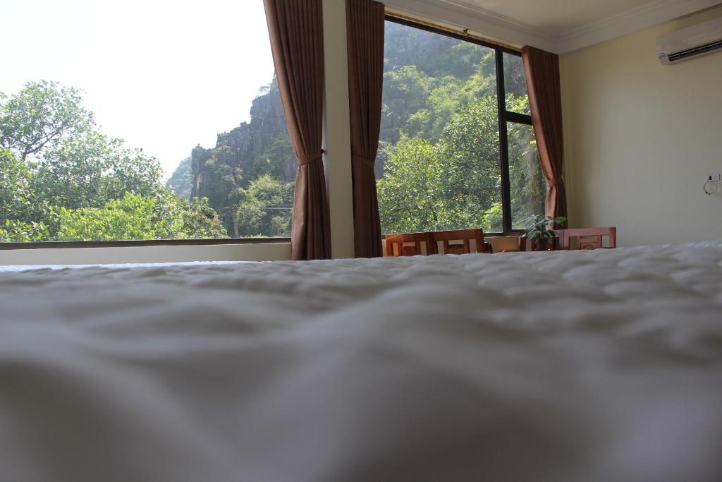 a bedroom with a bed and a large window at Sierra Homestay in Ninh Binh