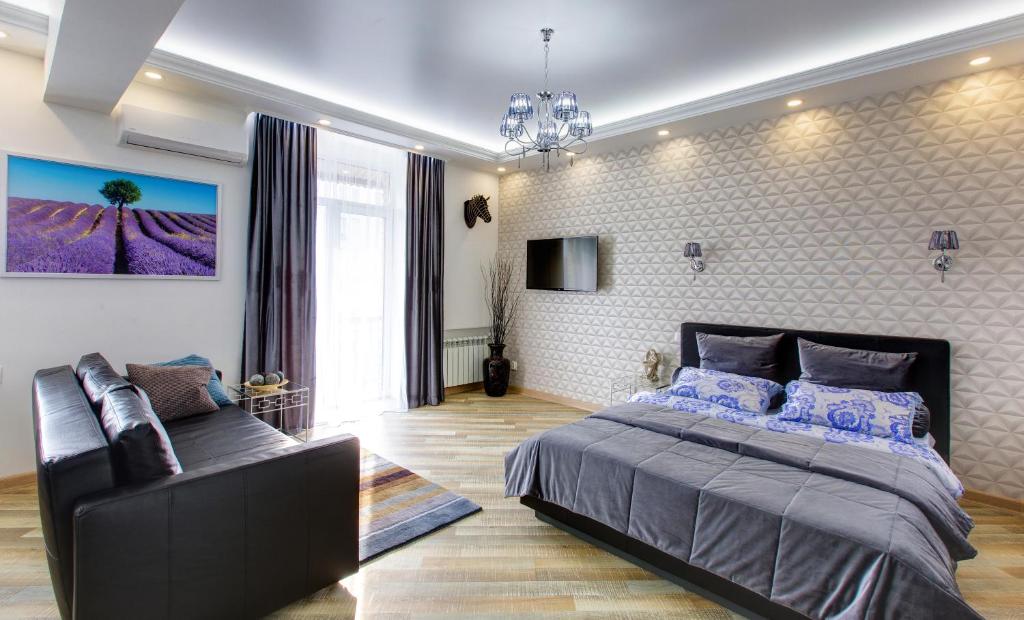 ウファにあるAzbuka Apartment on Babushkina 52のベッドルーム(ベッド1台、ソファ付)