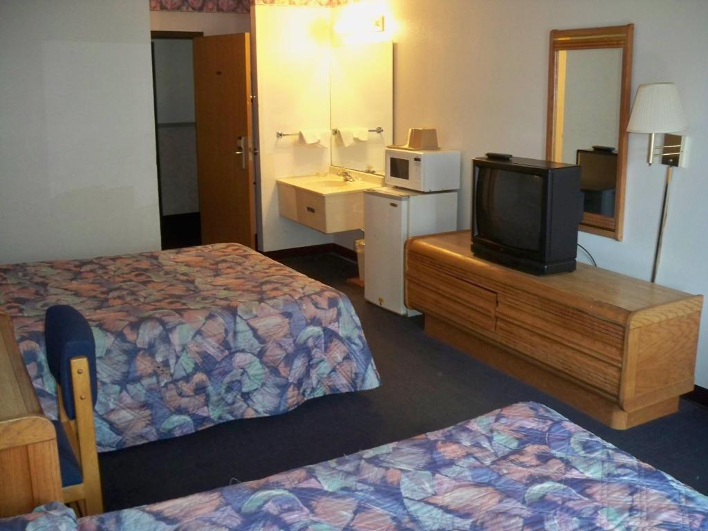 a hotel room with two beds and a television at Economy Inn Wentzville in Wentzville